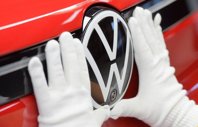 &copy; Reuters. Funcionário coloca logotipo da Volkswagen em um carro, na linha de produção de modelos elétricos do Grupo Volkswagen, em Zwickau, Alemanha. 26/04/2022. REUTERS/Matthias Rietschel