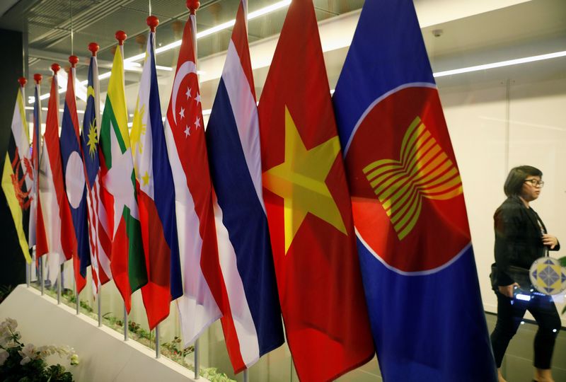 &copy; Reuters. FILE PHOTO: A woman passes ASEAN Summit flags at Suntec Convention Centre in Singapore, November 11, 2018. REUTERS/Edgar Su/File Photo