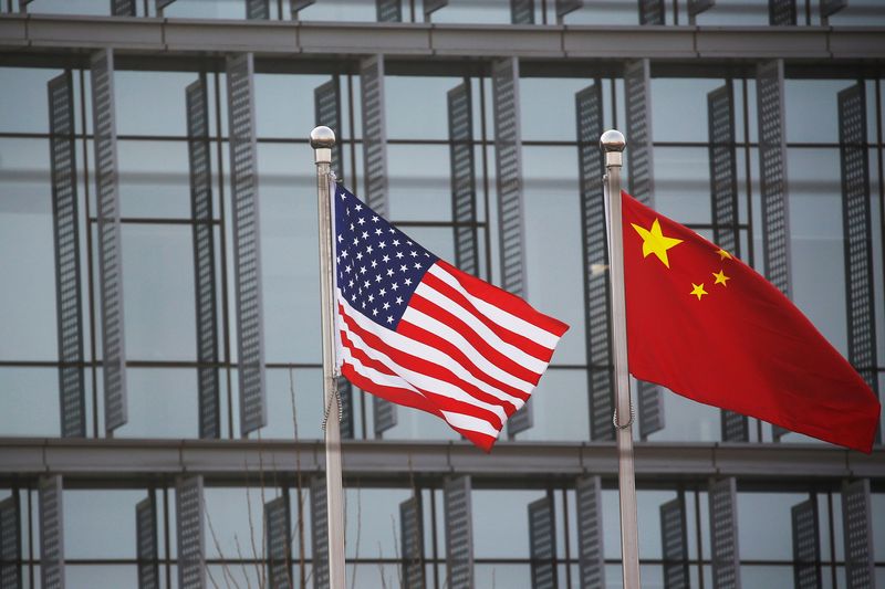 &copy; Reuters. Des drapeaux chinois et américains flottent devant le bâtiment d'une entreprise américaine à Pékin. /Photo prise le 21 janvier 2021/REUTERS/Tingshu Wang