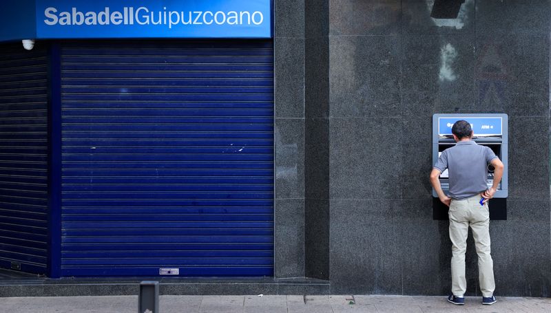 &copy; Reuters. FILE PHOTO: A man uses an automated teller machine at a branch of Sabadell bank in the Basque town of Guernica, Spain, October 26, 2022. REUTERS/Vincent West/File Photo