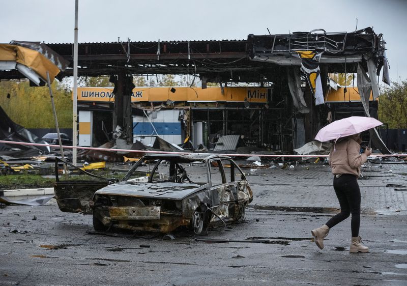 &copy; Reuters. Una mujer pasa frente a una gasolinera destrozada por un ataque aéreo ruso en Dnipro, Ucrania, el 26 de octubre de 2022. REUTERS/Mykola Synelnykov