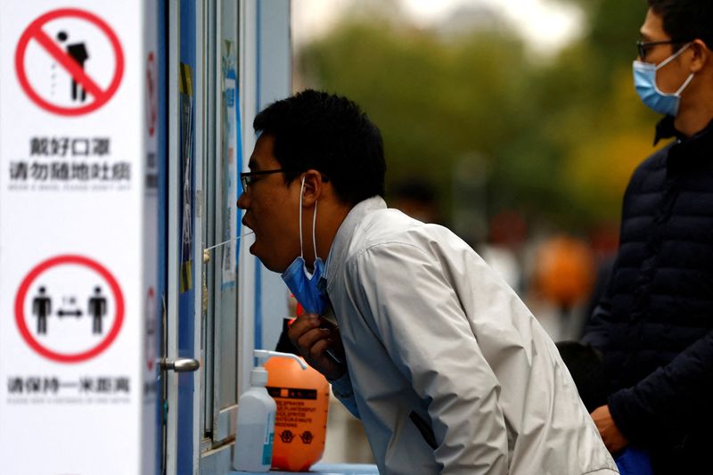 &copy; Reuters. FILE PHOTO: A man has his swab sample taken for a test for the coronavirus disease (COVID-19) at a testing booth, in Beijing, China October 27, 2022. REUTERS/Tingshu Wang/File Photo