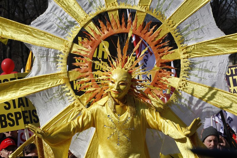 © Reuters. FILE PHOTO: A protester, wearing a sun costume, takes part in a demonstration against the German governments planned cuts in solar power incentives, in Berlin March 5, 2012.  REUTERS/Tobias Schwarz 