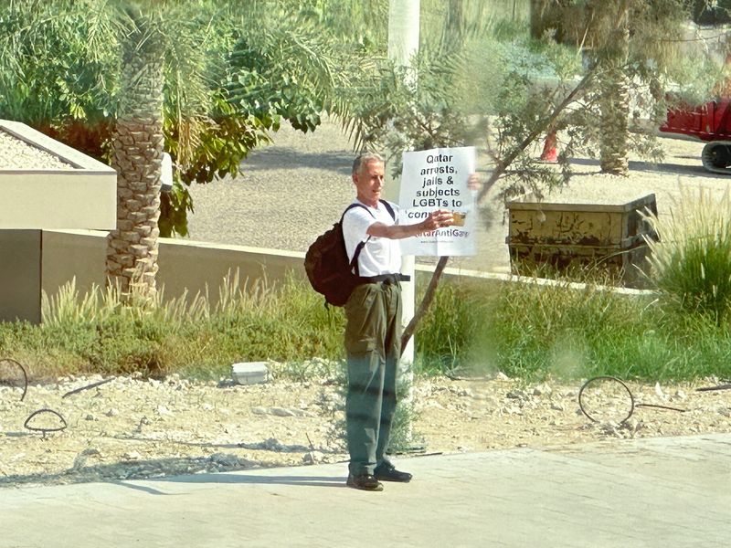 &copy; Reuters. الناشط البريطاني بيتر تاتشل المدافع عن حقوق مجتمع الميم يحمل لافتة أمام المتحف الوطني القطري في الدوحة يوم 25 أكتوبر تشرين الأول 2022. صورة لرو