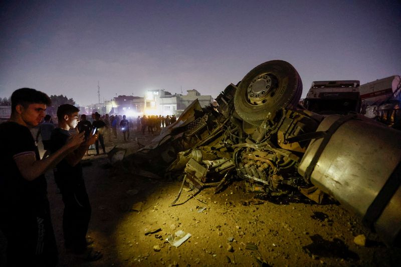 © Reuters. Iraqi people inspect the site where an explosive device attached to a vehicle detonated, leading to another explosion of a gas tanker that was close by, in Baghdad, Iraq, October 29, 2022. REUTERS/Thaier Al-Sudani