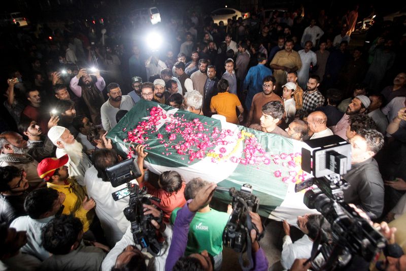 © Reuters. People carry the coffin, wrapped in the national flag, of Sadaf Naeema female journalist who was killed by a vehicle carrying  former prime minister Imran Khan, in an accident during what they call 'a true freedom march' to pressure the government to announce new elections, during her funeral in Lahore, Pakistan October 31, 2022. REUTERS/Mohsin Raza