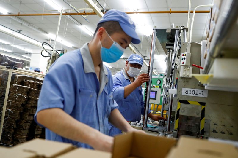 &copy; Reuters. FILE PHOTO: Employees wearing masks work at a factory of the component maker SMC during a government organised tour of its facility following the outbreak of the coronavirus disease (COVID-19), in Beijing, China May 13, 2020. REUTERS/Thomas Peter