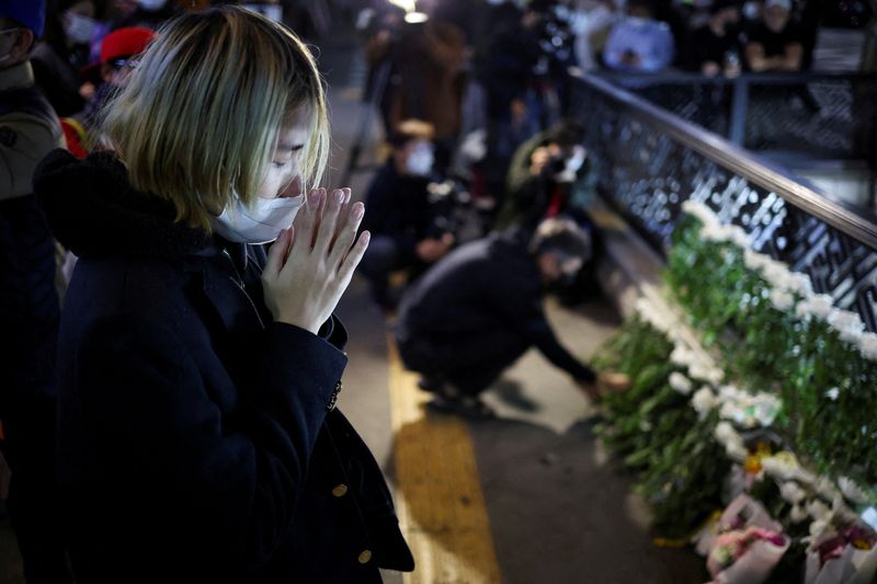 &copy; Reuters.     韓国の韓悳洙首相は３１日、首都ソウルの繁華街、梨泰院で２９日夜に起きた雑踏事故を受けて、原因を徹底的に調査すると述べた。写真は現場付近で手を合わせる女性、３０日撮影（