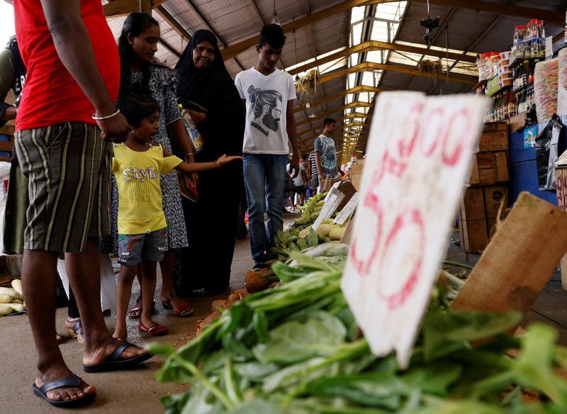 &copy; Reuters. FILE PHOTO: A family look around vegetables at a market in the rampant food inflation, amid Sri Lanka's economic crisis, in Colombo, Sri Lanka, July 30 , 2022. REUTERS/Kim Kyung-Hoon