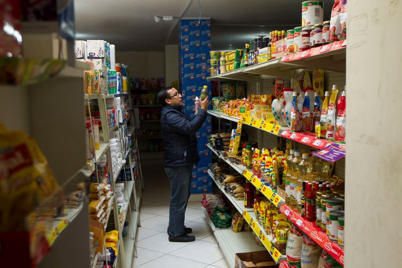 &copy; Reuters. FILE PHOTO: A man buys groceries at a market in Quito, Ecuador June 1, 2016. REUTERS/Guillermo Granja