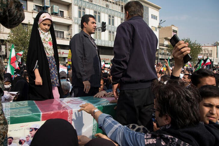 &copy; Reuters. 強硬な取り締まりで知られるイランの司法当局は首都テヘランの暴動で約１０００人を起訴し、近く公判を開く見通し。写真は、抗議行動中に死亡したイラン人男性の棺に集まる人々。２０