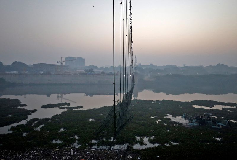 © Reuters. جسر المشاة الذي يمر فوق نهر ماتشو في بلدة موربي بولاية جوجارات الهندية بعد انهياره في صورة التقطت يوم الثلاثاء. صورة لرويترز. يحظر إعادة بيع الصورة أو الاحتفاظ بها في أرشيف.
