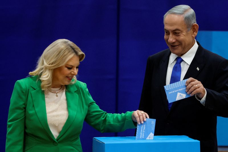 © Reuters. Former Israeli Prime Minister Benjamin Netanyahu stands next to his wife Sara as they cast their ballots on the day of Israel's general election in a polling station in Jerusalem November 1, 2022. REUTERS/Ammar Awad