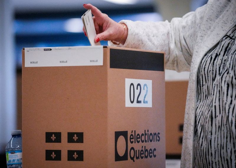 © Reuters. FILE PHOTO: A woman casts her ballot in an election in the riding of Chauveau in Quebec City, Quebec, Canada October 3, 2022. REUTERS/Mathieu Belanger/File Photo