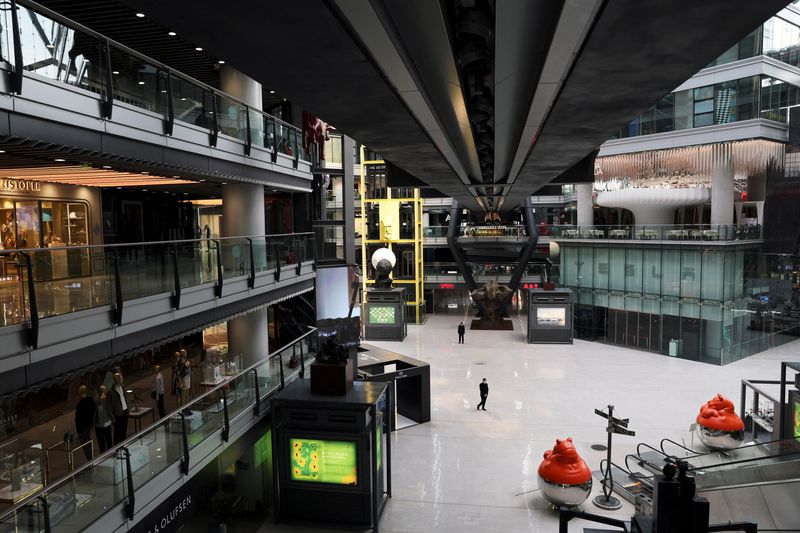 © Reuters. FILE PHOTO: People stand near a Tesla's showroom inside the Parkview Green shopping mall where most shops are closed, amid the coronavirus disease (COVID-19) outbreak in Beijing, China, May 9, 2022. REUTERS/Tingshu Wang/File Photo