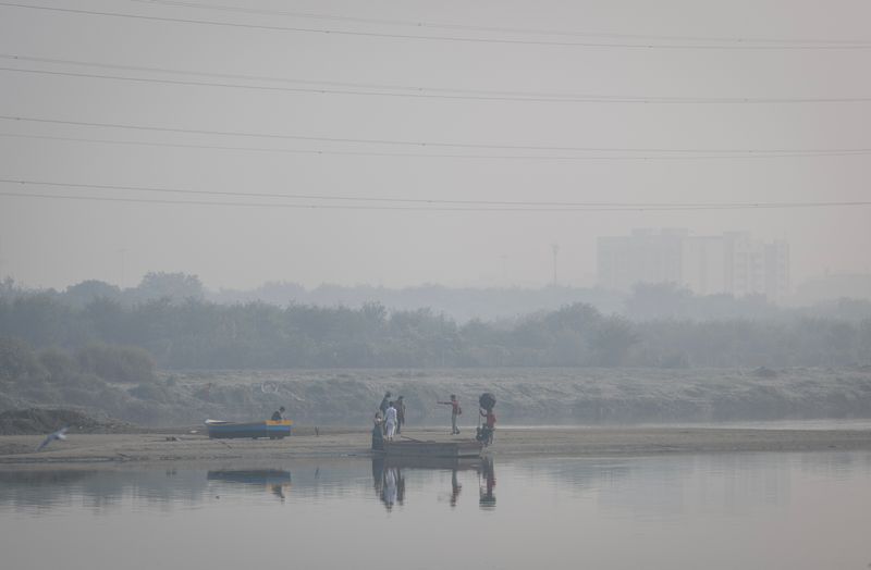&copy; Reuters. FILE PHOTO: A couple poses during a pre-wedding photo on the banks of Yamuna river on a smoggy morning in the old quarters of Delhi, India November 2, 2022. REUTERS/Adnan Abidi/File Photo