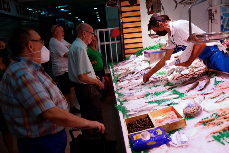 &copy; Reuters. FOTO DE ARCHIVO. Vendedores de la tienda Pescados Alfonso Vicancos atienden a los clientes en un mercado local de Madrid, España. 12 de agosto de 2022. REUTERS/Susana Vera