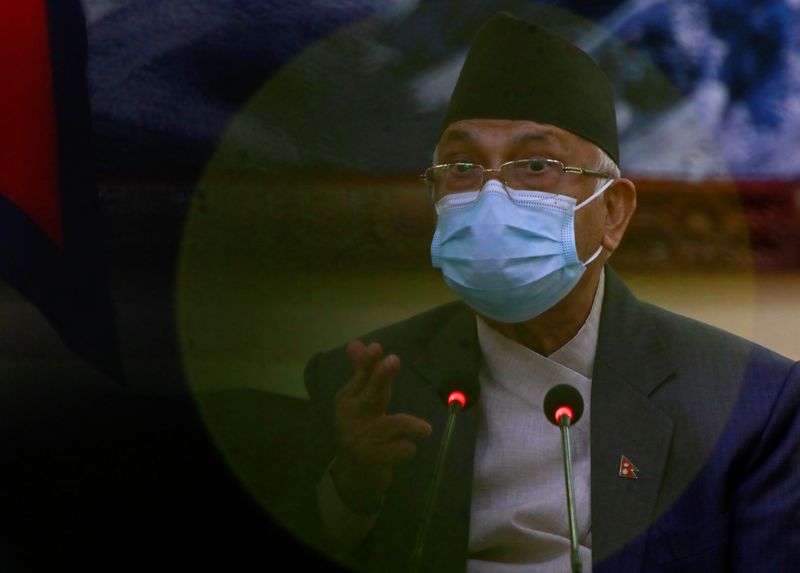 &copy; Reuters. FILE PHOTO: Nepal's Caretaker Prime Minister Khadga Prasad Sharma Oli, also known as K.P. Oli, sits in front of the picture of Mount Everest as he speaks with the media during a news conference, after the president dissolved the parliament and fixed gener