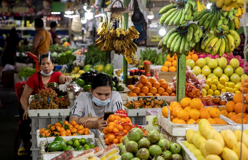 &copy; Reuters. FILE PHOTO: Vendors wearing face masks for protection against the coronavirus disease (COVID-19) stand by their fruit stalls at a public market in Quezon City, Metro Manila, Philippines, February 5, 2021. REUTERS/Eloisa Lopez