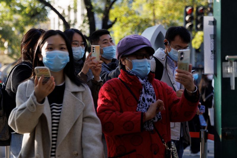 &copy; Reuters. أشخاص يضعون كمامات للوقاية من فيروس كورونا في بكين يوم السبت. تصوير: توماس بيتر - رويترز. 