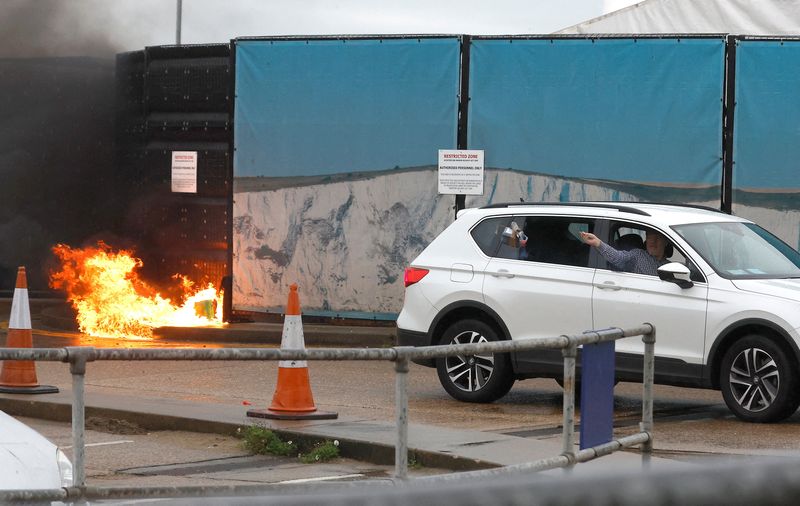 &copy; Reuters. FILE PHOTO: A man throws an object out of a car window next to the Border Force centre after a firebomb attack in Dover, Britain, October 30, 2022.  REUTERS/Peter Nicholls    