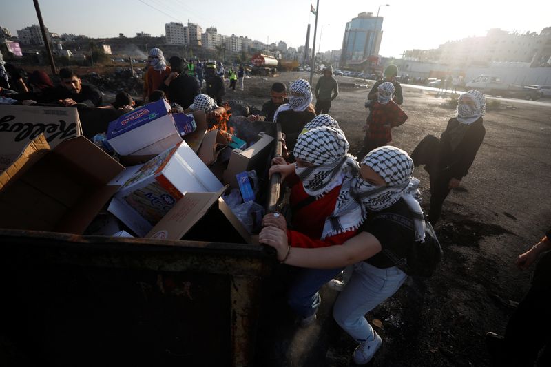&copy; Reuters. Palestinos empujan un contenedor de basura en medio de enfrentamientos con las fuerzas israelíes, durante una protesta cerca de Ramallah, en la Cisjordania ocupada por Israel. 5 de noviembre, 2022. REUTERS/Mohamad Torokman