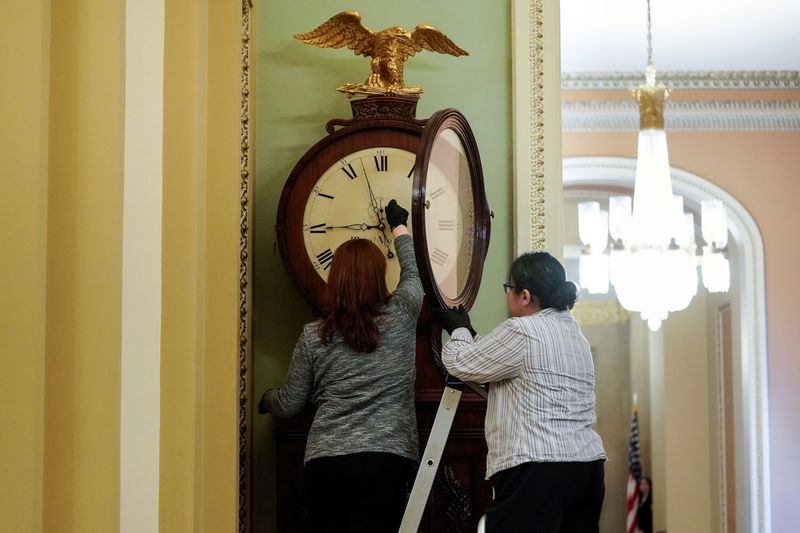 &copy; Reuters. FILE PHOTO: Employees with the Architect of the Capitol wind the Ohio Clock on the first day of the Senate impeachment trial of U.S. President Donald Trump on Capitol Hill in Washington, U.S., January 21, 2020. REUTERS/Joshua Roberts