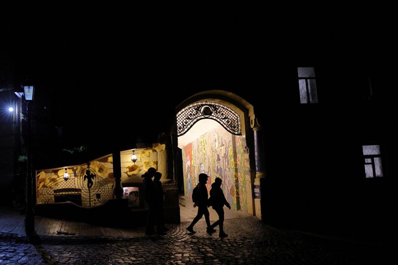 © Reuters. People walk on a dark street, as Russia's attack on Ukraine continues, in the old town of Kyiv, Ukraine November 6, 2022. REUTERS/Murad Sezer