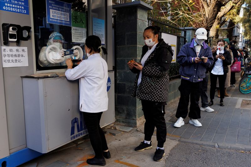 &copy; Reuters. 　１１月７日、中国国家衛生健康委員会は、新型コロナウイルス新規市中感染者が６日時点で５４９６人と、５月２日以来最多になったと発表した。写真は検査を受けるため、個人情報の登