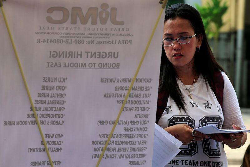 © Reuters. FILE PHOTO: An applicant looks for a job opening as she joins jobseekers at the Labor Day job fair sponsored by the local government in metro Manila, Philippines May 1, 2017. REUTERS/Romeo Ranoco
