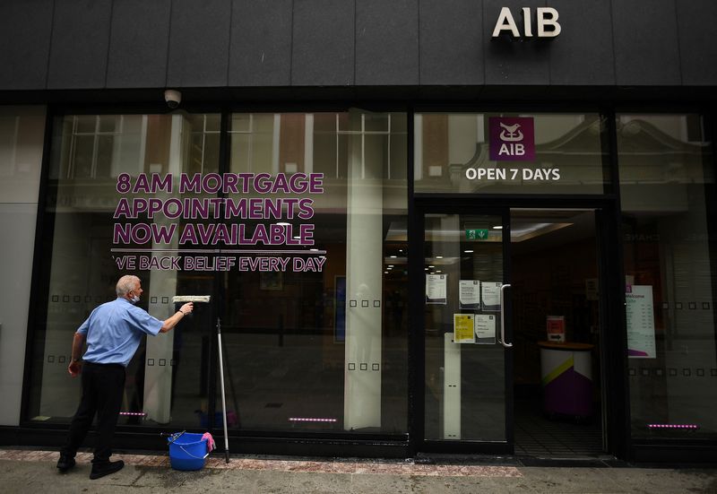&copy; Reuters. FILE PHOTO: An Allied Irish Bank (AIB) worker cleans the outside window of a branch of AIB featuring an advertisement offering mortgage appointments in Dublin, Ireland, March 1, 2021. REUTERS/Clodagh Kilcoyne