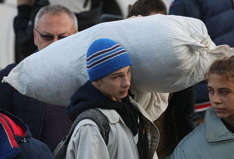 &copy; Reuters. FOTO DE ARCHIVO - Un joven lleva un saco mientras los civiles evacuados de la región ucraniana de Jersón, controlada por Rusia, y llegan a una estación de tren local, después de que las autoridades instaladas por Rusia emitieran una orden de evacuaci