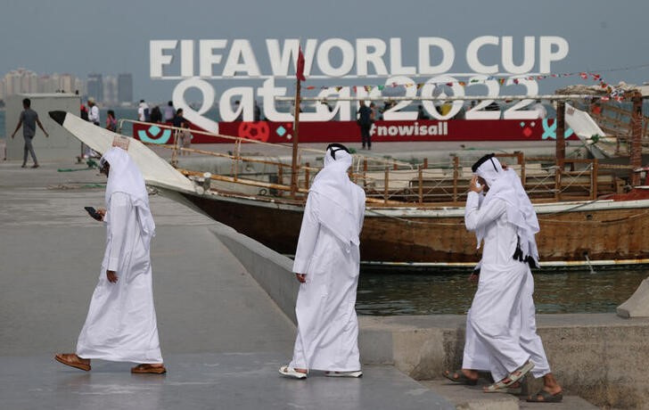 &copy; Reuters. Varias personas pasan frente a un anuncio del Mundial de Qatar en Doha, Qatar. 5 noviembre 2022. REUTERS/Ibraheem Al Omari