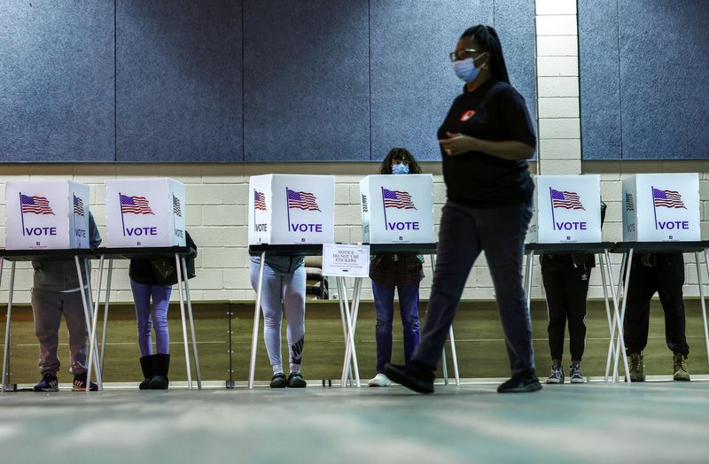 © Reuters. A poll worker walks past voters marking their ballots in the midterm election, at Considine Little Rock Recreation Center in Detroit, Michigan, November 8, 2022. REUTERS/Evelyn Hockstein