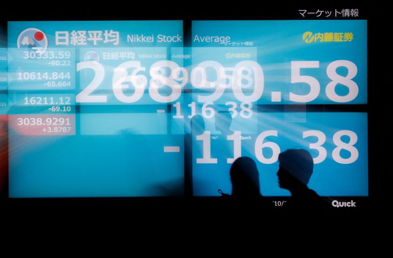 &copy; Reuters. FILE PHOTO: Silhouettes of passerby are seen as they walk in front of an electric monitor displaying Japan's Nikkei share average in Tokyo, Japan, October 21, 2022  REUTERS/Issei Kato