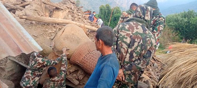 &copy; Reuters. Des membres de l'armée népalaise travaillent pendant une opération de sauvetage sur les ruines d'une maison effondrée, endommagée après un tremblement de terre survenu tôt mercredi, dans le district occidental de Doti, au Népal. /Photo prise le 9 
