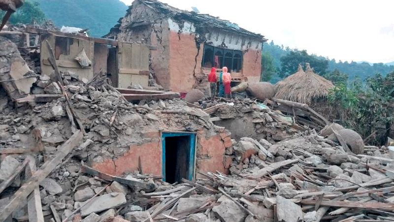 &copy; Reuters. Unas personas permanecen frente a las ruinas de las casas derrumbadas tras un terremoto ocurrido a primera hora del miércoles, en el distrito occidental de Doti, Nepal. 9 de noviembre de 2022. Ejército de Nepal/Handout vía REUTERS 