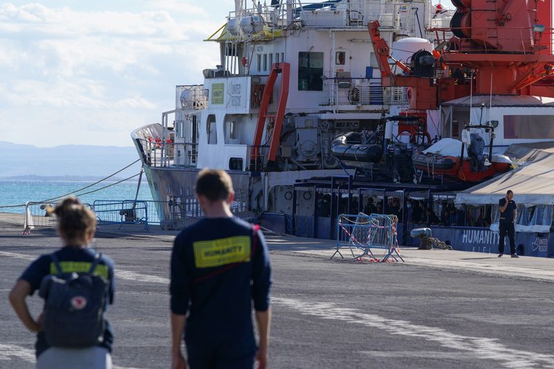 &copy; Reuters. FOTO DE ARCHIVO. Personas caminan frente al barco de rescate de la ONG "Humanity 1" en el puerto de Catania, en Sicilia, Italia. 7 de noviembre de 2022. REUTERS/Antonio Parrinello