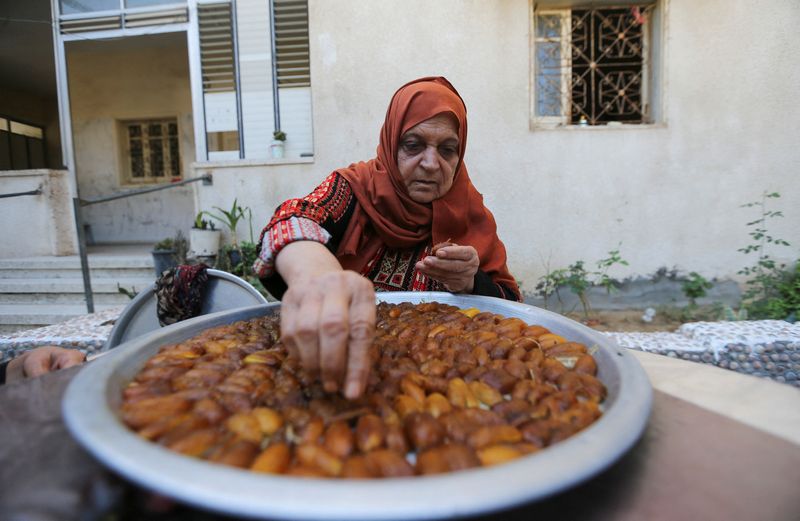&copy; Reuters. سيدة فلسطينية تصنع العجوة باستخدام تمور طازجة بعد قطفها من أشجار النخيل في دير البلح وسط قطاع غزة. تصوير: إبراهيم أبو مصطفى - رويترز.