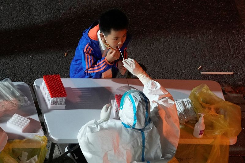 &copy; Reuters. Un garçon subit un test de dépistage de la maladie à coronavirus (COVID-19) dans un site de tests d'acide nucléique, suite à l'épidémie de maladie à coronavirus (COVID-19) à Shanghai, en Chine. /Photo prise le 9 novembre 2022/REUTERS/Aly Song