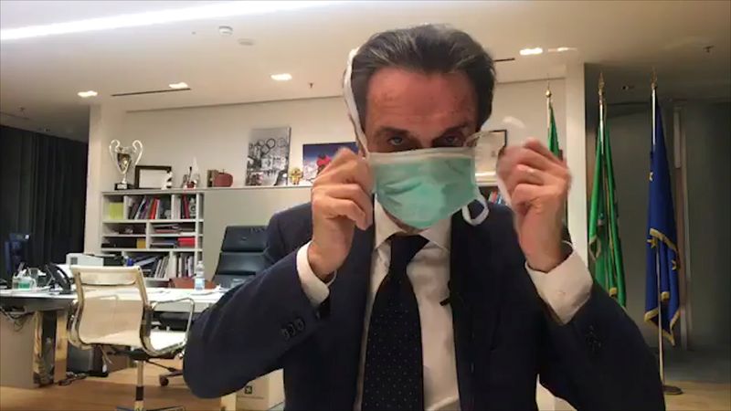 &copy; Reuters. Il governatore della Lombardia Attilio Fontana indossa una maschera protettiva mentre annuncia su Facebook di essersi messo in quarantena dopo che uno dei suoi collaboratori è risultato positivo al coronavirus, in questo fermo immagine tratto da un video
