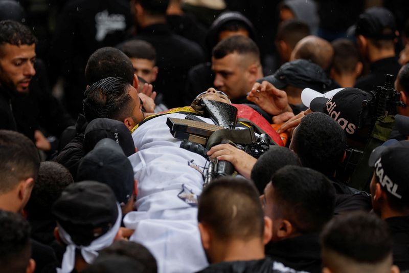 © Reuters. مشيعون يحملون جثمان مهدي حشاش خلال جنازته في نابلس بالضفة الغربية المحتلة يوم الأربعاء. تصوير محمد تركمان- رويترز.