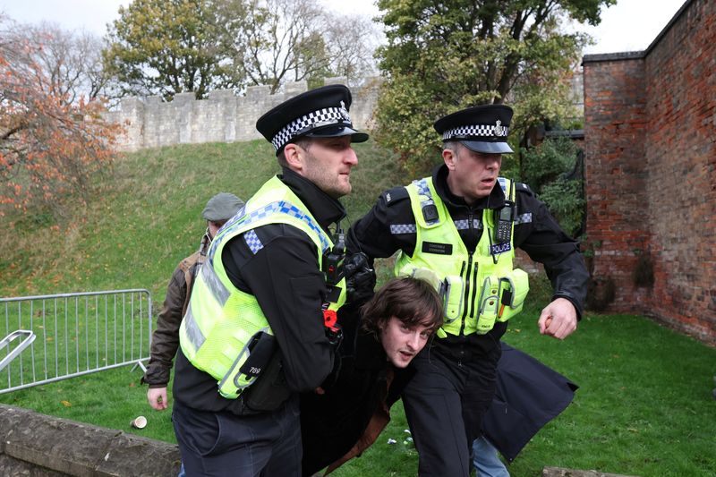 &copy; Reuters. Agenti di polizia allontanano un uomo arrestato per aver lanciato un uovo a Re Carlo durante la visita a Micklegate Bar a York, Gran Bretagna, 9 novembre 2022. REUTERS/Russell Cheyne