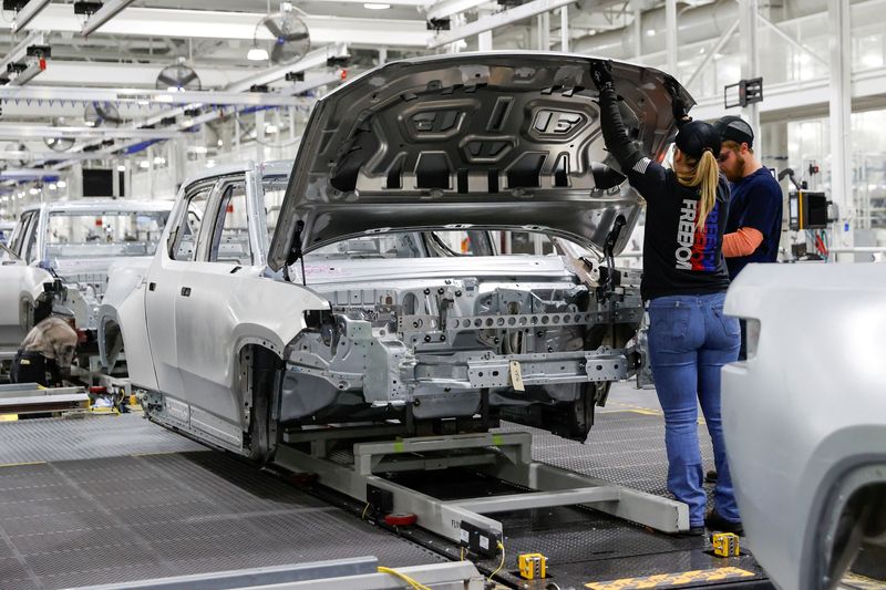 © Reuters. FILE PHOTO: Employees work on an assembly line at startup Rivian Automotive's electric vehicle factory in Normal, Illinois, U.S. April 11, 2022.   REUTERS/Kamil Krzaczynski/File Photo