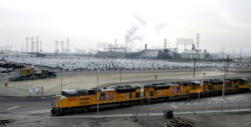 © Reuters. FILE PHOTO: A set of Union Pacific freight locomotives roll past a holding lot with Toyota automobiles at the Port of Long Beach in California December 4, 2008.  REUTERS/Fred Prouser/File Photo