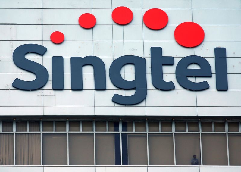 © Reuters. FILE PHOTO: A man looks out of the window under a Singtel signage at their head office in Singapore February 12, 2015.  REUTERS/Edgar Su