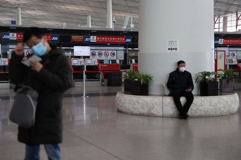 © Reuters. FILE PHOTO: Travellers wait at a terminal hall of the Beijing Capital International Airport in Beijing, China March 23, 2022. REUTERS/Tingshu Wang