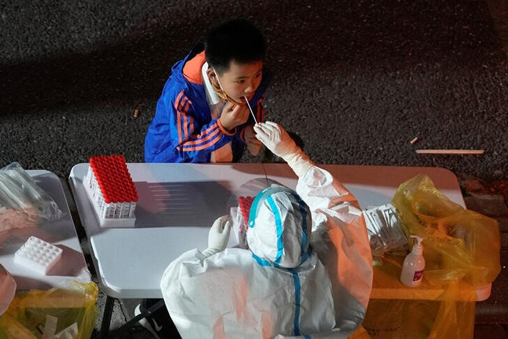 &copy; Reuters. 　中国当局は新型コロナウイルス対策でもっと的を絞ったアプローチを取り、「過度な措置」は是正すべきと、国営新華社通信が１０日報じた。写真は上海で９日、検査を受ける少年（２０