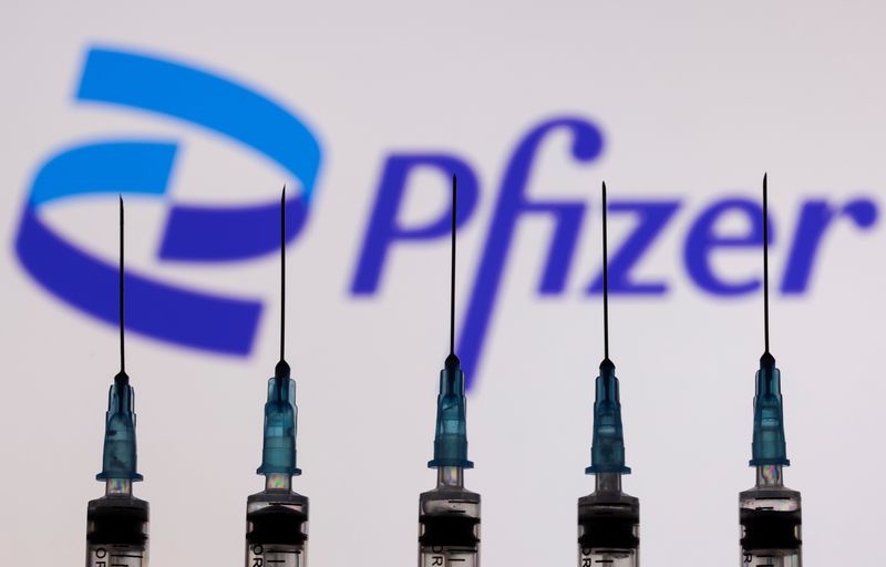 &copy; Reuters. Siringhe con aghi davanti al logo Pfizer in questa illustrazione del 27 novembre 2021. REUTERS/Dado Ruvic/Illustration