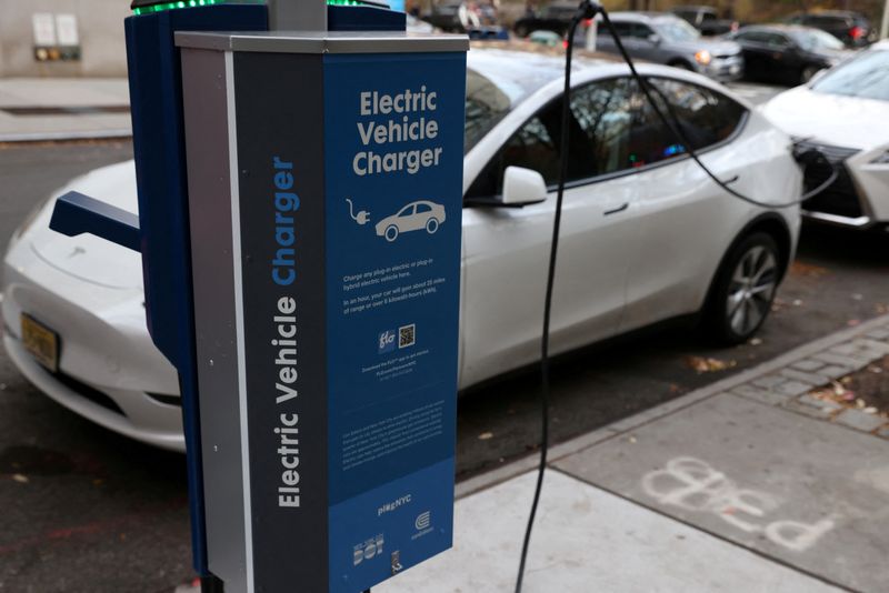 © Reuters. FILE PHOTO: A electric vehicle charger is seen as a vehicle charges in Manhattan, New York, U.S., December 7, 2021. REUTERS/Andrew Kelly